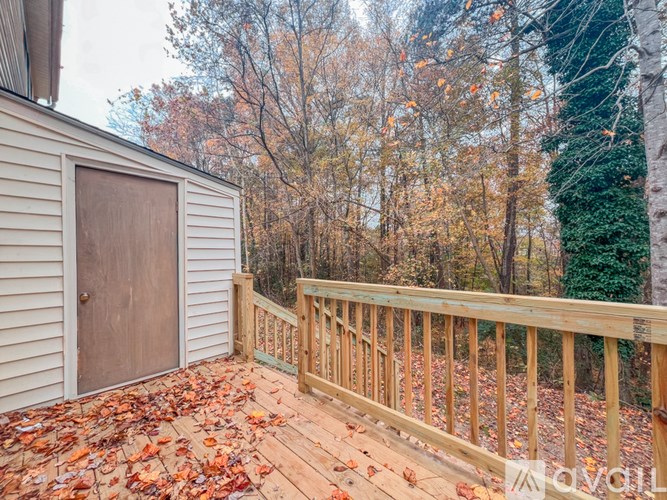 A wooden deck with a brown door and a railing.