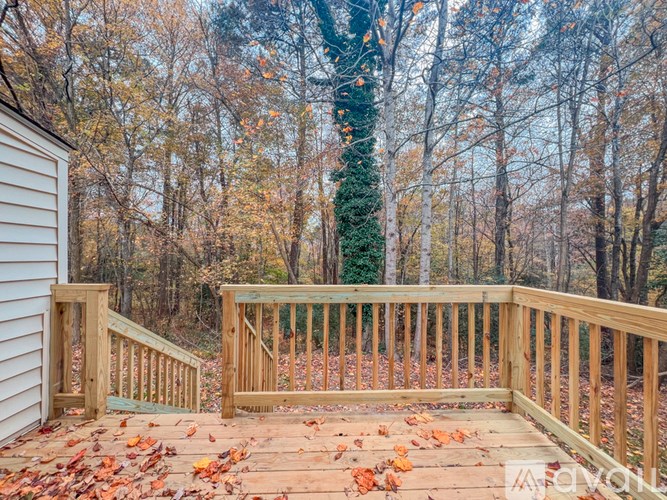 A deck with a railing and steps leading to a house.