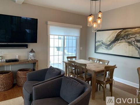 A living room with a grey couch, a wooden table, and a painting on the wall.