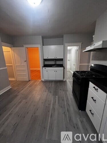 A kitchen with a black counter top and white cabinets.