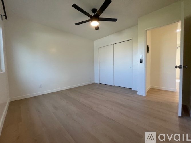 A room with a ceiling fan and a door.