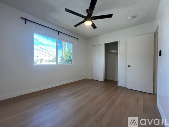 A room with a ceiling fan and a window with a view of the outside.