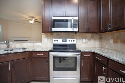 A kitchen with brown cabinets and a stove top oven.