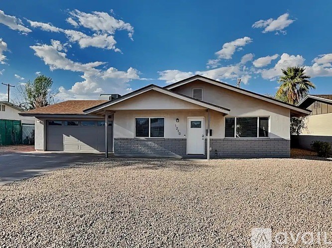 A house with a gravel driveway in front.