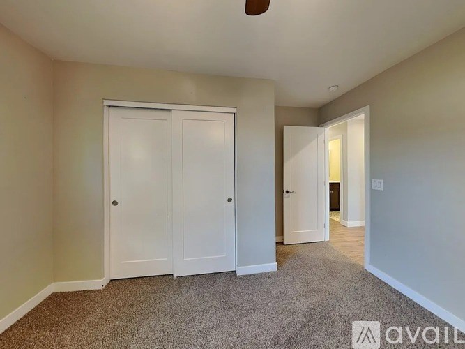 A room with a carpeted floor and two white doors.
