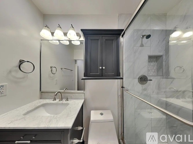 A bathroom with a marble countertop and a walk-in shower.