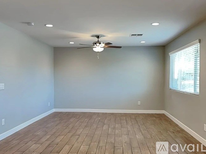 A spacious room with a ceiling fan and lighting fixture.