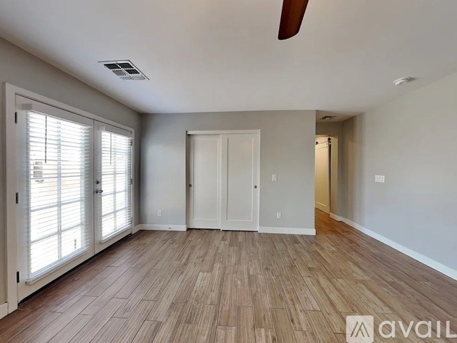 A room with wooden flooring and a ceiling fan.