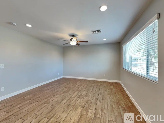 A room with wooden flooring and a ceiling fan.