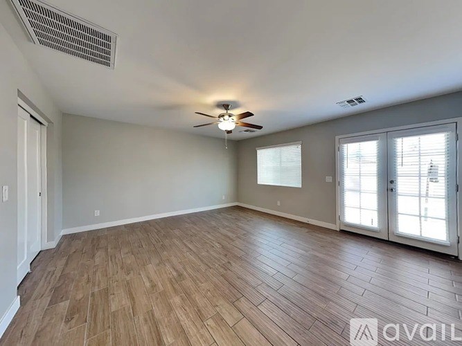 A room with wooden flooring and a ceiling fan.