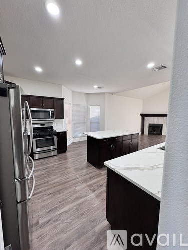 A modern kitchen with a refrigerator, oven, and countertops.