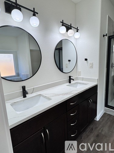 A bathroom with two sinks and two mirrors.