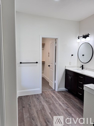A bathroom with a white door and a round mirror on the wall.