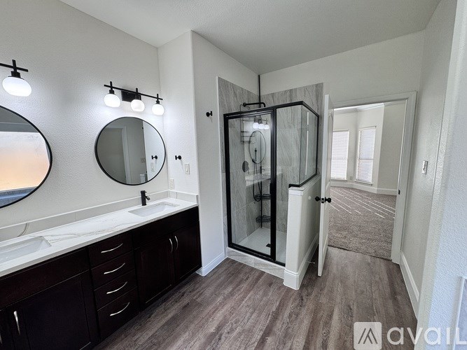 A bathroom with a sink, mirror, and a walk-in shower.