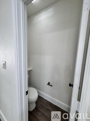 A white toilet in a small bathroom with a white door.