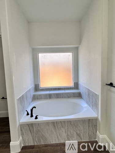 A bathroom with a tub and a window.