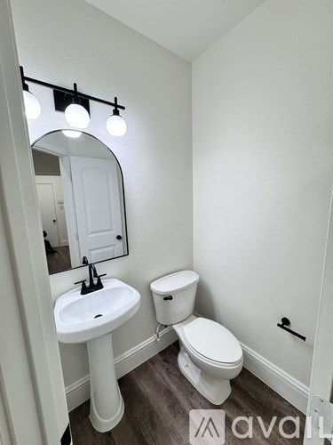 A white bathroom with a sink, toilet and mirror.