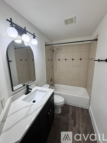 A bathroom with a white sink and a white toilet.