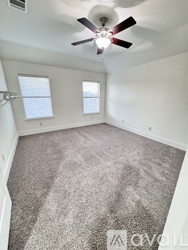 A room with a ceiling fan and carpeted floor.
