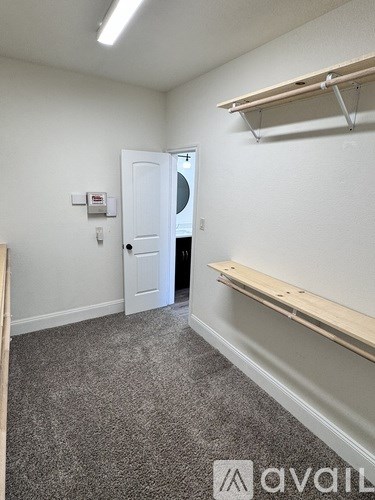 A room with a white door and a white wall with a small red box on it.