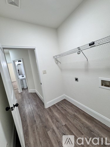 A room with a white wall and a grey floor.