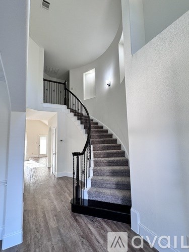 A staircase with a black railing and wooden steps.