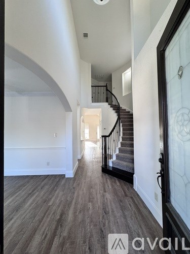 A hallway with a staircase and a glass door.