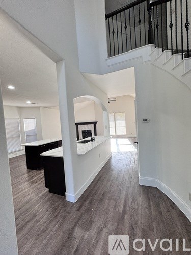 A spacious interior of a house with a staircase and a desk.