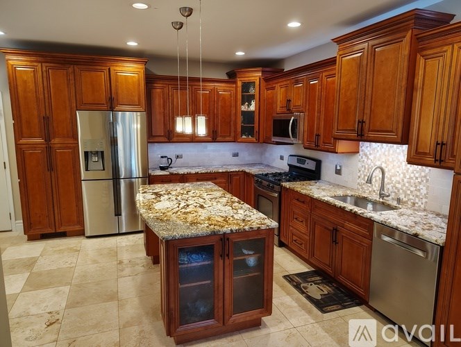 A kitchen with wooden cabinets and granite countertops.