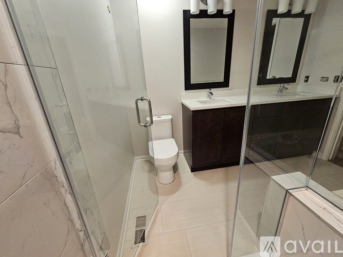 A bathroom with a toilet, sink, and mirror.