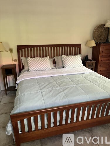 A bed with a wooden headboard and two pillows is in the image.