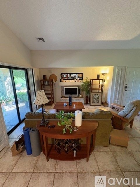 A living room with a brown table and a white lamp.