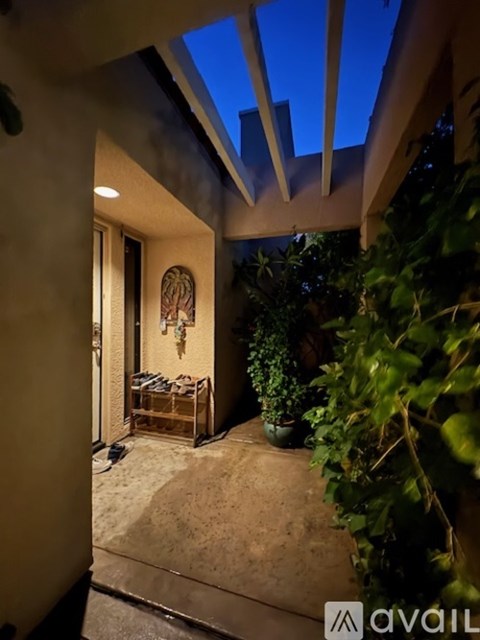 A patio area with a table and chairs under a roof.