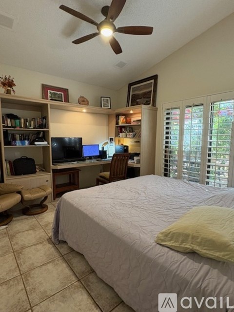 A bedroom with a bed, desk, and chair.