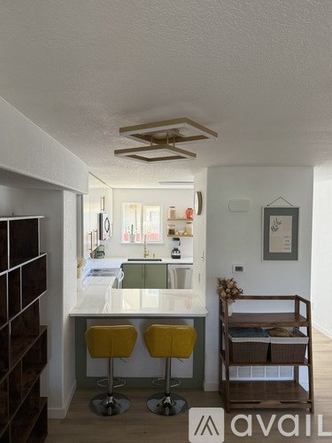 A kitchen with a white counter top and yellow stools.