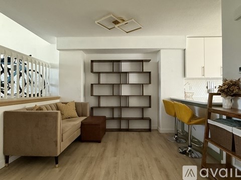 A living room with a brown sofa and a wooden shelf.