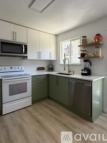 A kitchen with white cabinets and a white stove top oven.