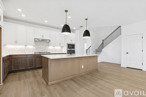 A kitchen with wooden floors and a large island.
