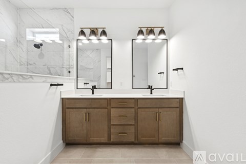 A bathroom with a marble wall and wooden cabinets.
