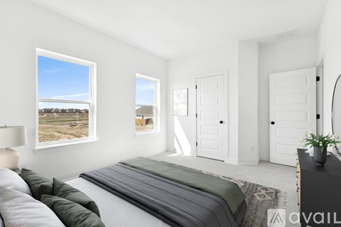 A bedroom with a large bed and a view of a field through the window.