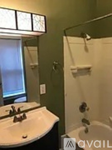 A bathroom with a white sink and a glass shower door.