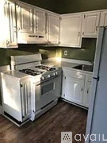 A kitchen with white appliances and cabinets.