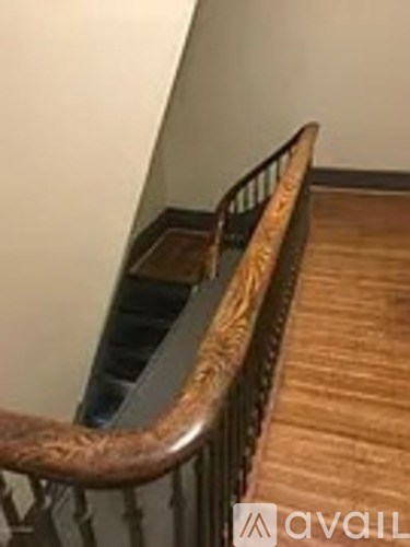 A wooden staircase with a metal railing.