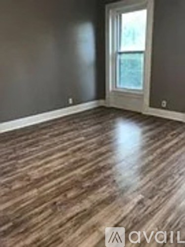 A room with wooden flooring and a window.