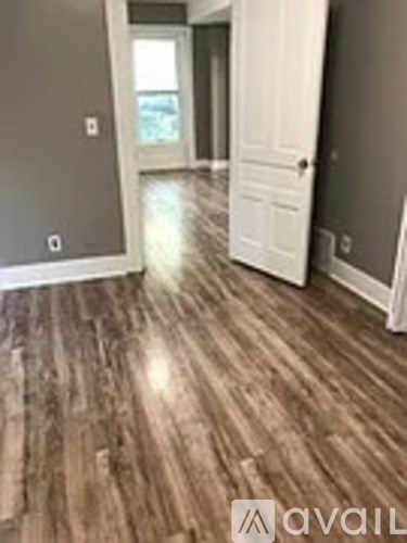 A hallway with wood flooring and white doors.