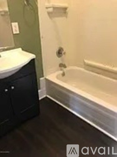 A bathroom with a white sink and a bathtub.