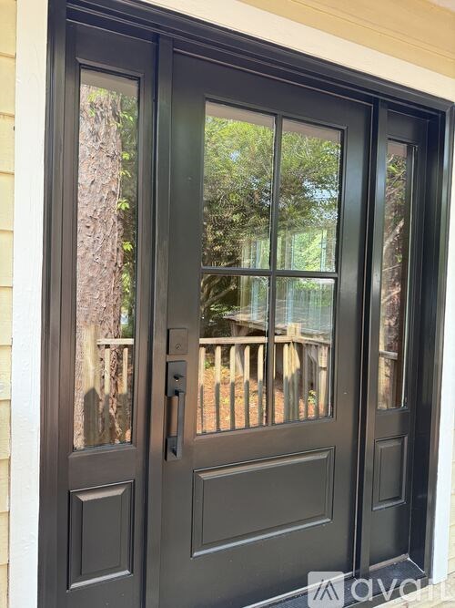 A black double door with a glass window and a handle.