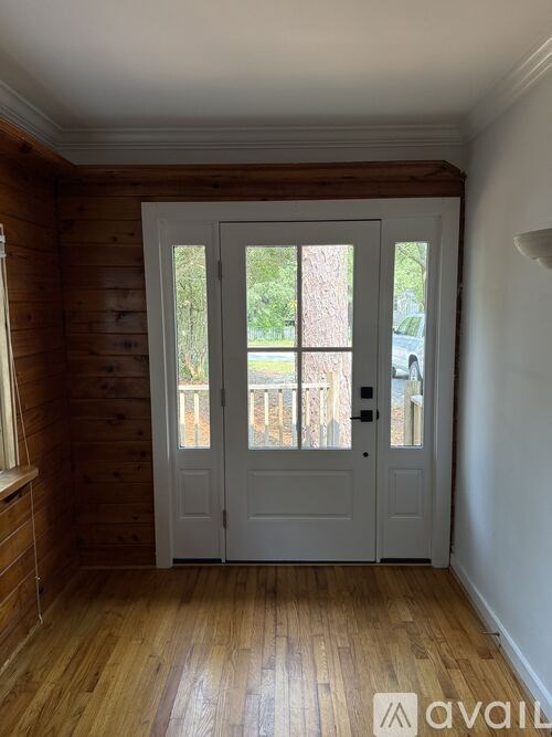 A room with wooden walls and a white door.