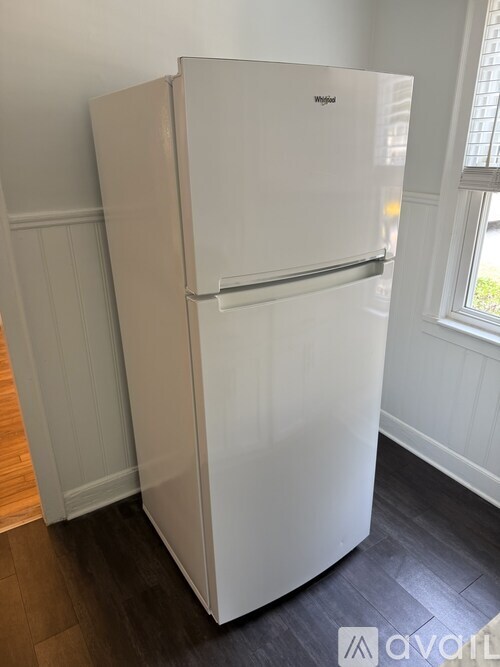 A white Whirlpool refrigerator in a kitchen.