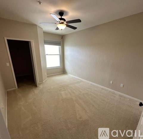 A room with a ceiling fan and a window.